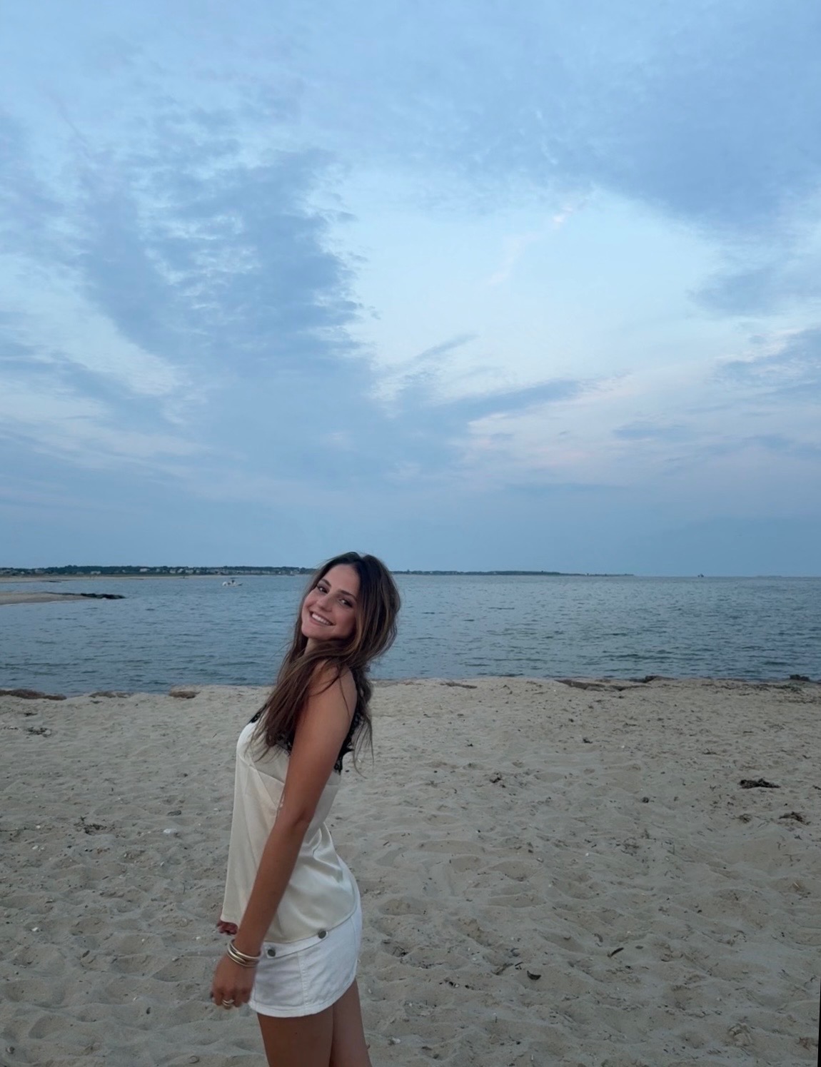 Vivi Myles smiling on a beach at dusk